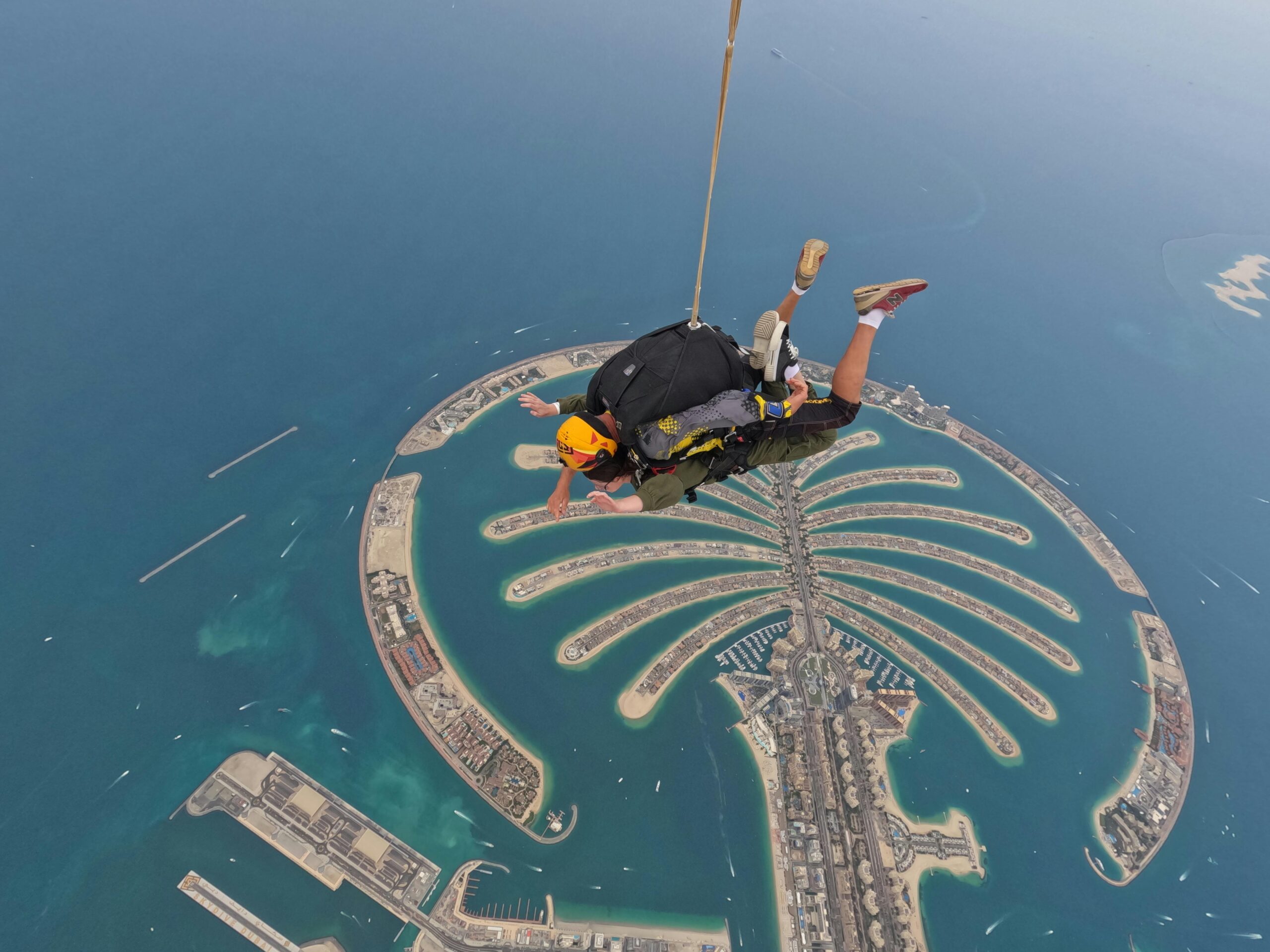 Skydiver floating above iconic Palm Jumeirah, showcasing Dubai's remarkable landscape.