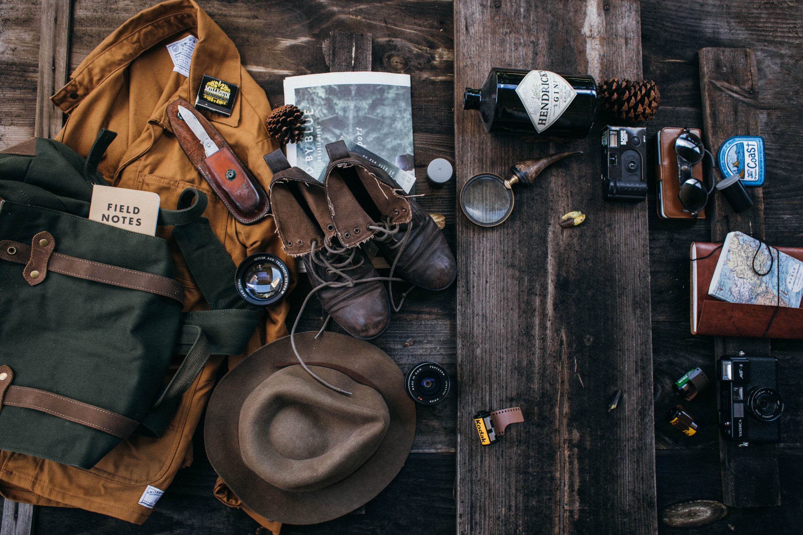 Outdoor hiking scene with boots and camera on a wooden surface, perfect for adventure themes.